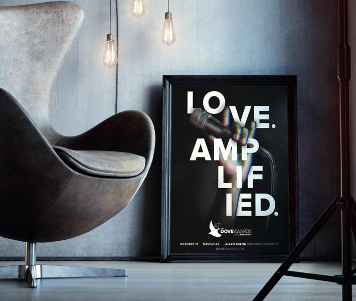A black chair next to a branded framed poster that says love amplified.