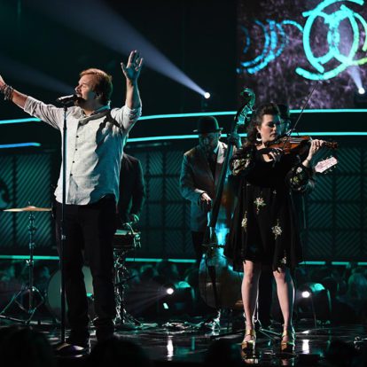A man and a woman performing on stage at the CMT Awards, showcasing their brand in their captivating singing and harmonious web design.