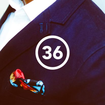 A man in a suit with the number 36 on his pocket, showcasing sleek design.
